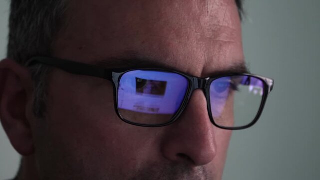Reflection of Computer Screen on Glasses, Person Scrolling in Social Media on Pc, Close Up Shot