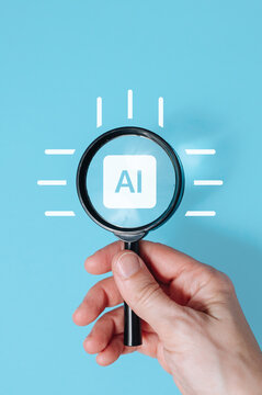 Hand holding magnifying glass over AI artificial intelligence sign on blue background, tech innovation search concept