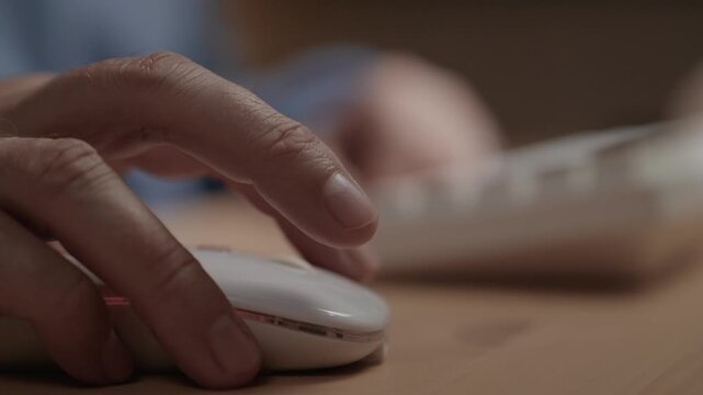 Close-up of user fingers pressing buttons of computer mouse. Computer work, remote work, freelance work concept. Close-up