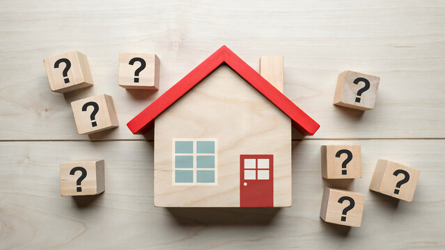 A small wooden house model surrounded by many scattered question mark blocks
