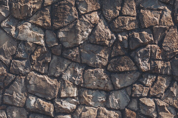 Natural stone wall showcases a beautiful array of textures and colors, inviting a sense of rugged elegance to any surroundings © Cristina