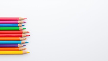 Fototapeta premium Stacked bright color pencils on simple white background with copy space supporting art learning in kids