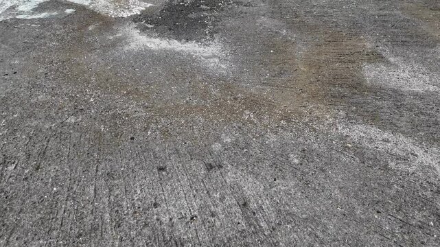 a high-angle view of a rough, weathered concrete surface.