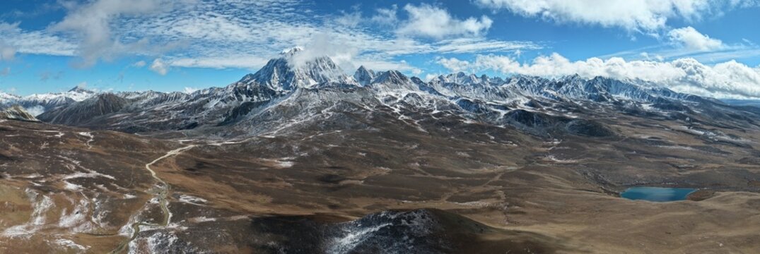 Wide aerial panorama of Yala Snow Mountain with drifting clouds, Sichuan, China