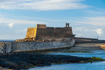 Stone castle with cannons on display at Arrecife, Lanzarote, Canary Islands. Historical fortress and stunning ocean backdrop © Kotangens