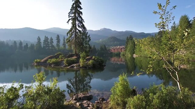 Serene Alpine Lake Reflection of Mountain Lodge and Pine in Whistler BC