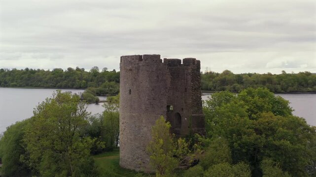 Aerial orbit of Cloughoughter Castle on a tranquil evening showcasing Lough Oughter in background. Ireland