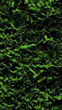 Shredded paper. Close-up of dense black cut and crumpled paper strips forming chaotic layered texture. Smooth continuous rotation reveals dynamic shifts in light and deep shadows.