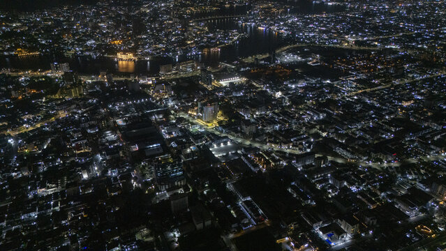 Aerial view of the illuminated city skyline and the Coastal Road at night with dense urban buildings and water bodies across Lekki, Lagos, Nigeria.
