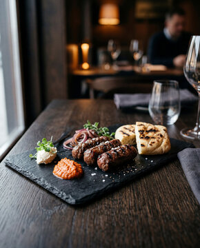 Grilled Chevapi sausages with red onion dip flatbread