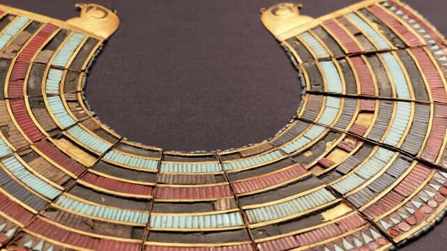 Closeup of ancient Egyptian broad collar pectoral necklace with gold turquoise and carnelian inlay from Tutankhamun treasure.