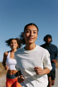 Closeup female runner leading a group outdoors in casual training gear for fitness poster and morning workout background