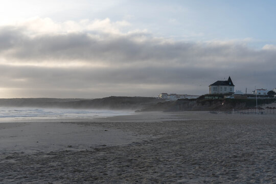 Morning on an empty beach, with distinctive building on headland Baleal, Peniche, Portugal
