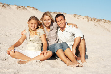 Fototapeta premium Portrait, parents and hug with child at beach for love, adventure and bonding on holiday. Smile, affection and people at seaside with daughter, connection and embrace with family for summer vacation