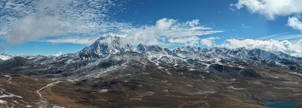 Wide aerial panorama of Yala Snow Mountain with drifting clouds, Sichuan, China
