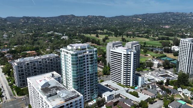 Drone shot of Westwood highrise buildings next to a lush golf course in Los Angeles