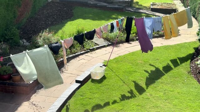 Fresh washed Laundry hanging on a clothes line blowing in the summer breeze and drying without the use of electricity, Worcestershire, England.