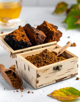 A wooden box filled with brown powder and chunks on a white surface
