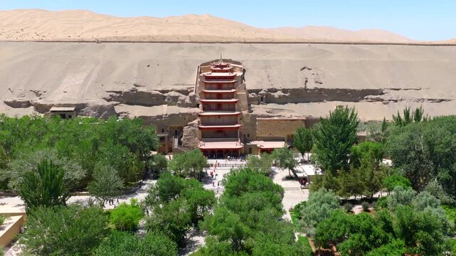 Aerial view of the Mogao Grottoes in Dunhuang, Gansu, China, showcasing the Buddhist statues and murals carved into the caves, and highlighting the art of Chinese murals.
