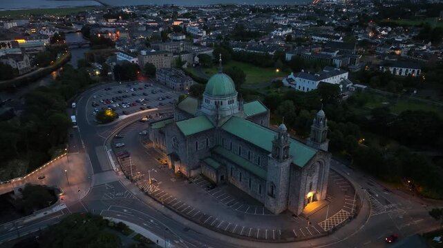 Galway old town night drone view, Galway is a city on the Atlantic coast of Ireland, Galway cathedral and Salmon Weir bridge aerial view with night illumination, tourism in Ireland