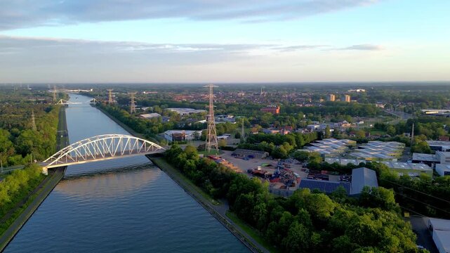 Aerial drone footage flying over Albert Canal arch bridge near Herentals Olen lock in Belgium at golden hour
