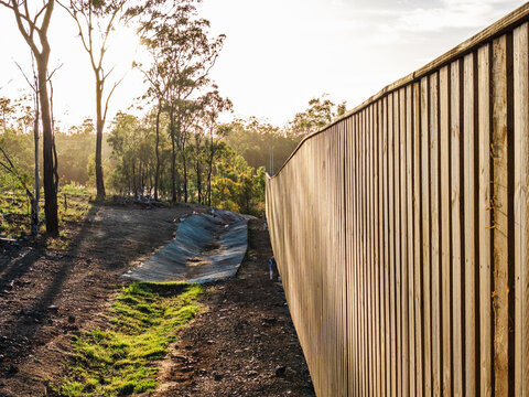 Wooden fence next to drainage ditch