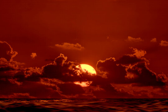 Sun rising through clouds over Atlantic Ocean