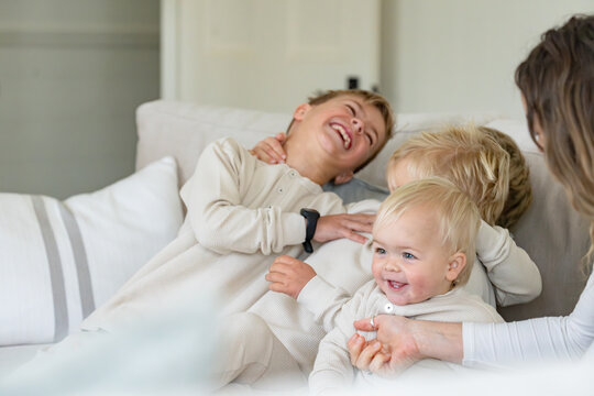 Young boys sitting on the couch laughing and smiling