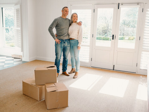 Couple standing in new home with boxes