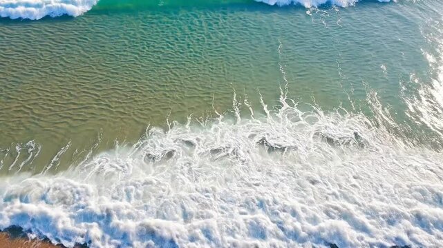 Ocean wave crashing on sandy beach shore.