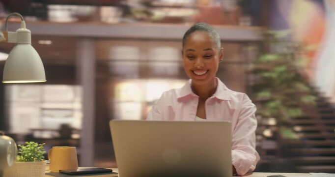 360 Degree. Smiling Black Businesswoman Analyzes Ecommerce Sales Charts on Laptop in Office, Leveraging Digital Software for Payment Processing and Business Growth. Orbital Cinematic Arc Tracking Sho