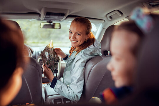 Smiling woman navigating with map during family road trip in car