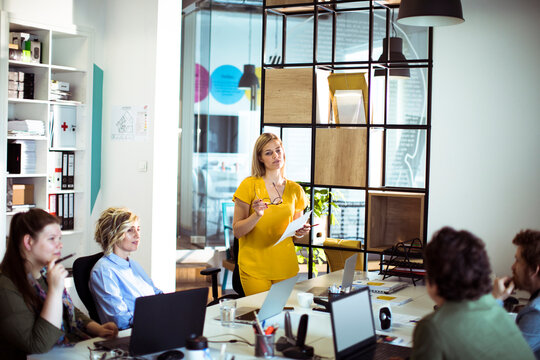 Team meeting with woman presenting in modern office