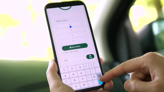 User tapping the numeric keypad to log daily nutrition on a health app. Entering calories and macros before saving. Ideal for diet tracking, food journaling, and mobile data entry stock footage.