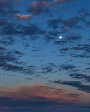 Moon rising on cloudy sky