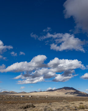 White puffy clouds above Interstate 80 crossing barren landscape