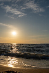 Obraz premium Vertical shot of beautiful golden sunset over sea beach