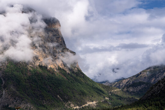 Clouds drifting around rugged mountain cliffs above Upper Pisang, Annapurna Circuit, Nepal Himalayas