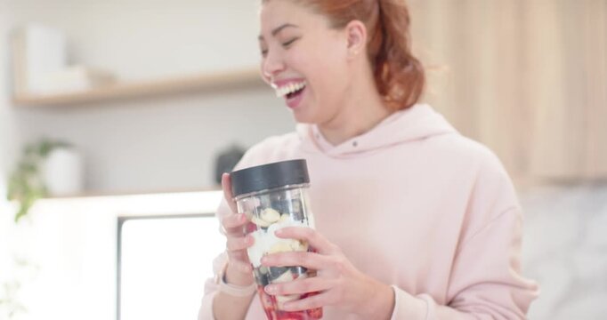 Diverse female pals passing blender cup, pink-hoodie woman securing lid and mixing drink on counter
