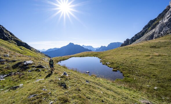 Mountaineer at a mountain lake, Sonnenstern, Luggauer T&ouml;rl, Karnischer H&ouml;henweg, Karnischer Hauptkamm, Carnic Alps, Carinthia, Austria