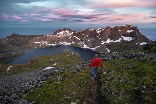Sunset with dramatic clouds, hiker on hike to Hermannsdalstinden, lakes Krokvatnet and Tennesvatnet, mountains, Moskenes&oslash;ya, Lofoten, Nordland, Norway