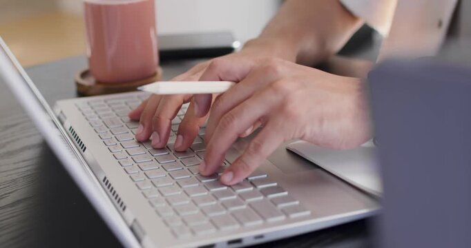 African American man placing hands on laptop, typing and tapping white stylus, working at desk