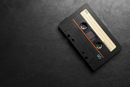 Black audio tape compact cassettes on black background.
