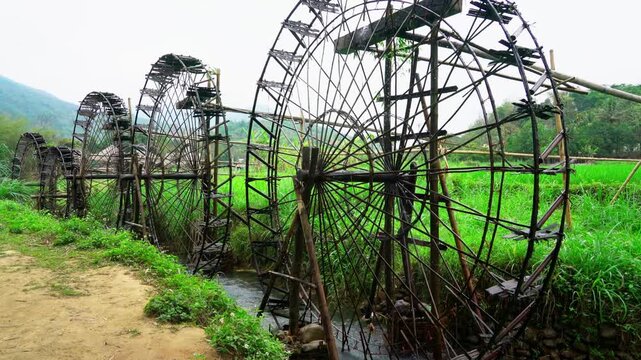 Traditional Wooden Water Wheel in Vietnam Rice Fields Ancient Hydraulic Irrigation System for Sustainable Agriculture and Rural Farming Landscape