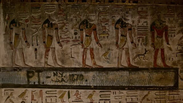 Close-up of ancient Egyptian relief carving inside KV17 tomb of Seti I, Valley of the Kings, Luxor, Egypt, showing a deity figure with black hair and deteriorating pigment.