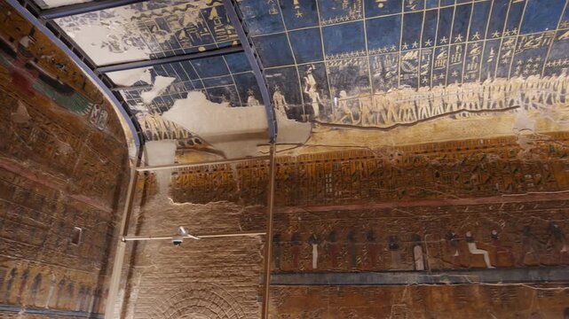 Close-up of ancient Egyptian relief carving inside KV17 tomb of Seti I, Valley of the Kings, Luxor, Egypt, showing a deity figure with black hair and deteriorating pigment.