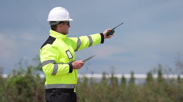 Engineer inspection industrial safety hard hat high visibility two way radio clipboard tablet guiding construction worker outdoors, site monitoring report, compliance checklist, site check