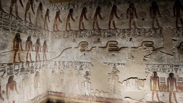 Close-up of ancient Egyptian relief carving inside KV17 tomb of Seti I, Valley of the Kings, Luxor, Egypt, showing a deity figure with black hair and deteriorating pigment.