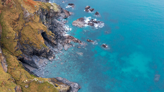 Aerial view of the rugged cliffs at Hell's Mouth with turquoise water and rocky outcrops along the coastline in Camborne, Cornwall, United Kingdom.