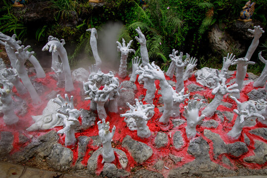 Ethereal white hands rise from vibrant red soil creating a dreamlike atmosphere in a captivating landscape